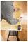 A person measures a wooden board with a yellow tape measure on a sawhorse, preparing for cutting in a carpentry task.