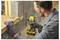 A person wearing safety gear uses a yellow power drill to screw wood planks together in a construction setting.