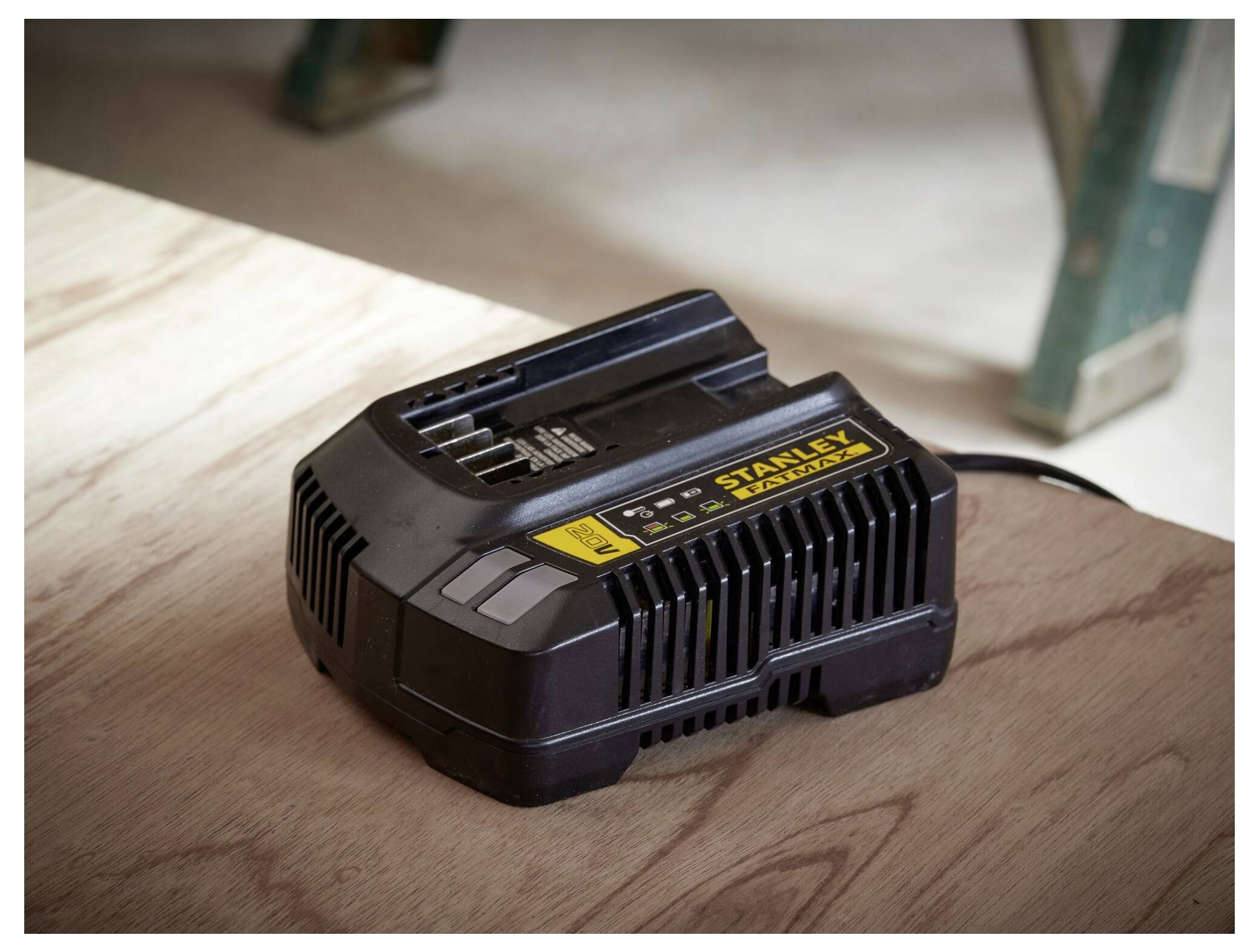 'A black Stanley FatMax battery charger resting on a wooden surface.'