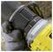 A gloved hand adjusts a power drill's torque setting. The drill is black and yellow, with textured grips and numbered settings visible.