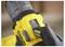 A gloved hand adjusts the torque setting on a yellow and black power drill.