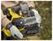 A person is holding a yellow power tool with a visible chain and blade guard. The tool is a 'Stanley Fatmax,' meant for cutting.