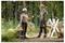 Two people in protective gear, holding chainsaws, stand in a forest clearing among cut logs, seemingly discussing their work.