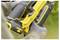 'A person holding a yellow power tool with gloved hands, focusing on adjusting a switch on the tool, suggesting usage or maintenance.'