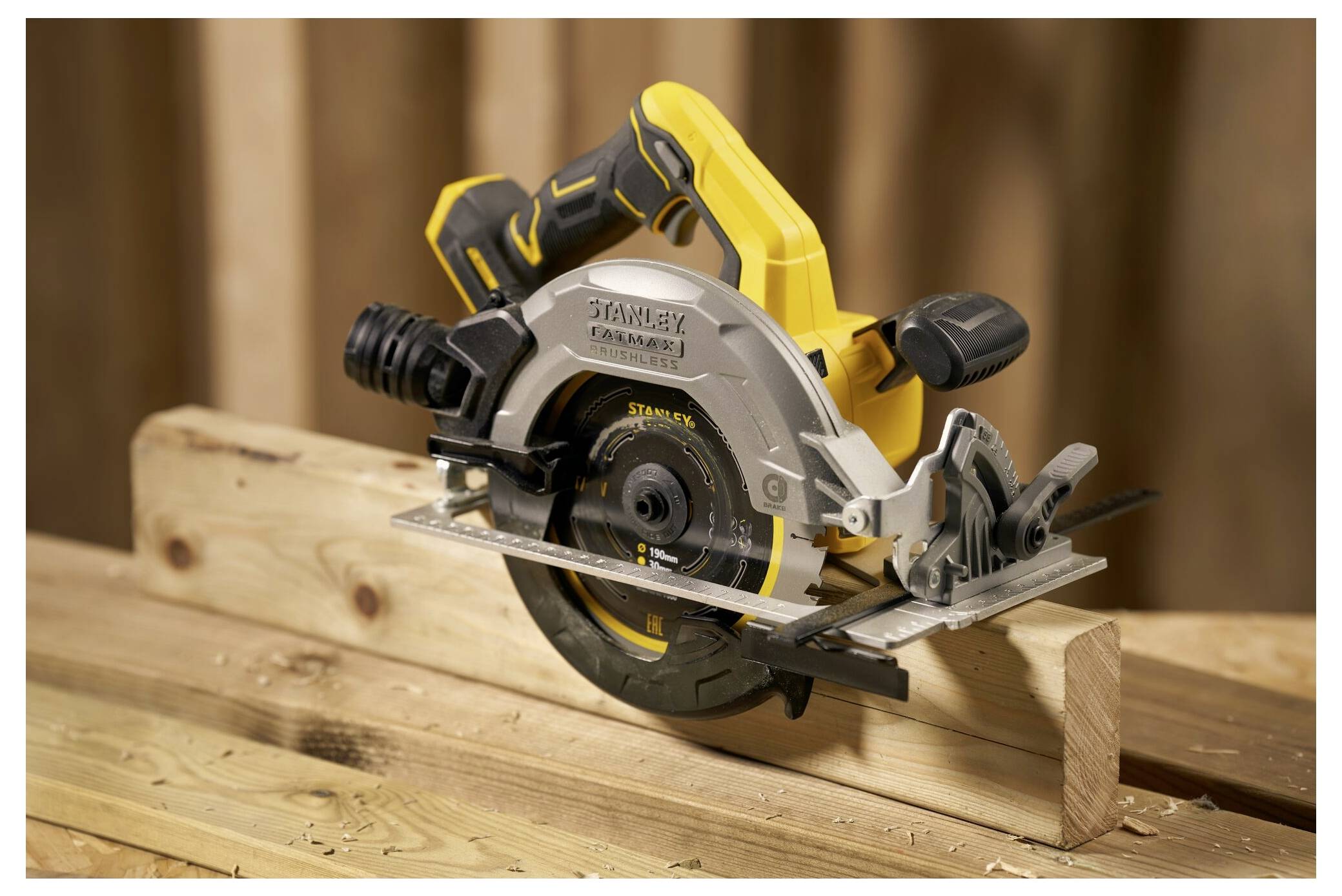 A yellow and black circular saw resting on wooden beams, displaying brand name on the side, with a focus on its blade and handle design.