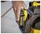 A person inserts a '20V Lithium Ion 4.0Ah' battery into a yellow and black power tool on a concrete floor.