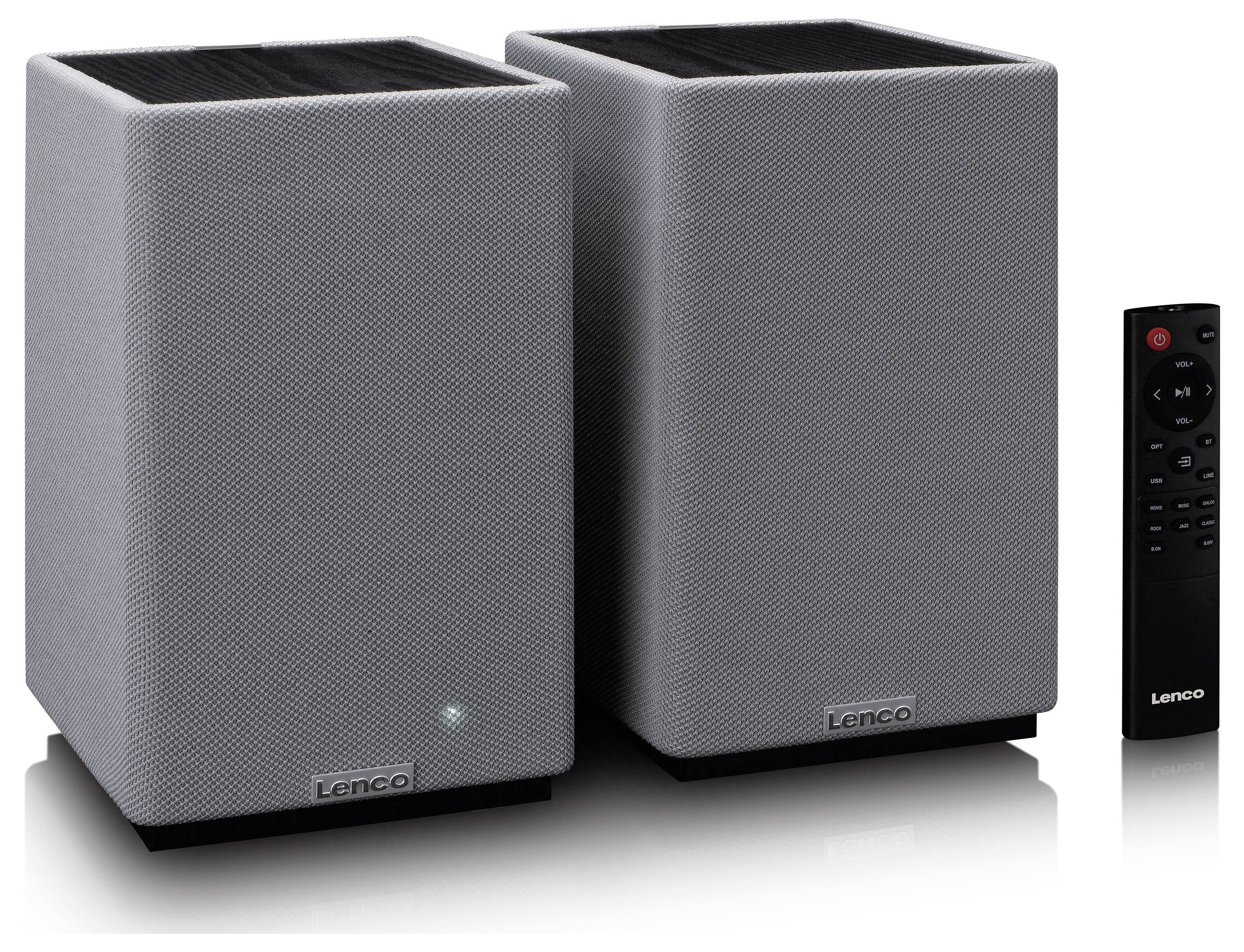 Two gray rectangular speakers with fabric fronts and a small LED light on one, accompanied by a black remote control.