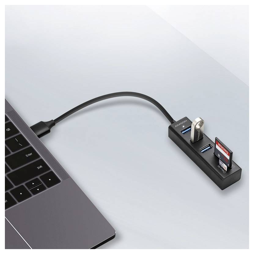 Laptop connected by USB-C cable to a black hub with USB ports, SD card slot, and a flash drive inserted.<br>