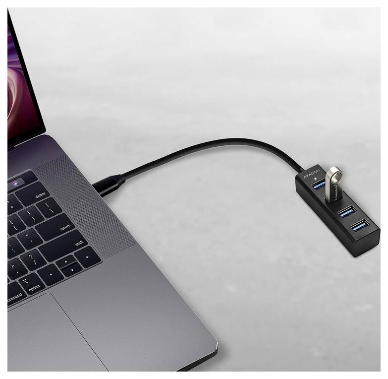 Laptop connected by USB-C cable to a small hub with multiple USB ports and a plugged-in flash drive.