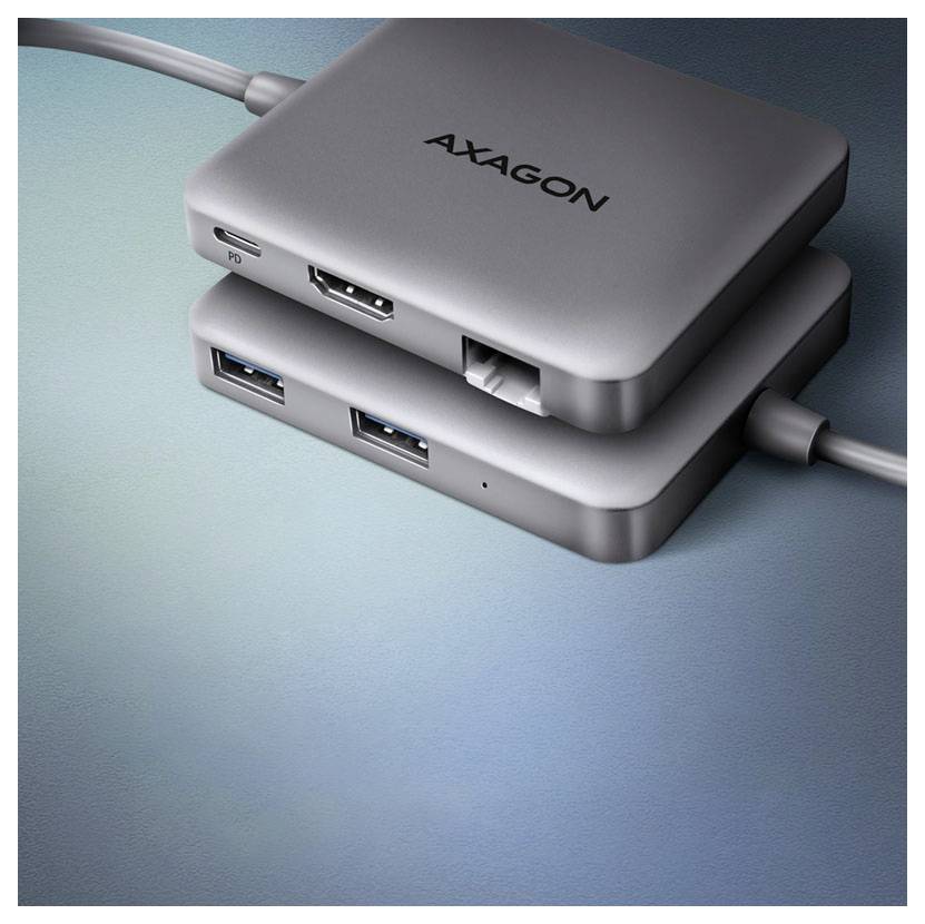 Two stacked AXAGON USB hubs on a blue surface, showing multiple USB ports and connected cables.<br>