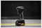 Black DeWalt cordless impact driver standing upright on a concrete floor with a yellow line, against a dark industrial background.<br>