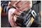 Close-up of a hand adjusting the release button on a DeWalt battery pack attached to a power tool.
