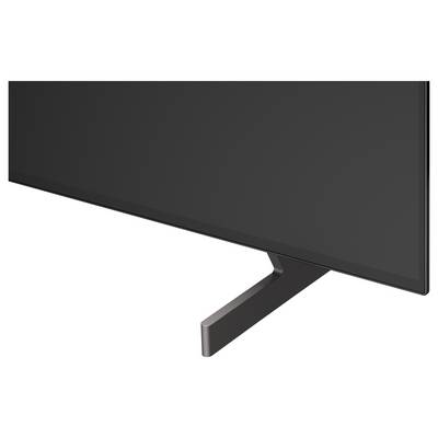 Close-up of a flat-screen TV or monitor showing the lower edge and angled stand on a white background.