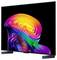 Flat-screen TV displaying a vivid abstract rainbow swirl on a black background, shown at an angle on two dark feet.