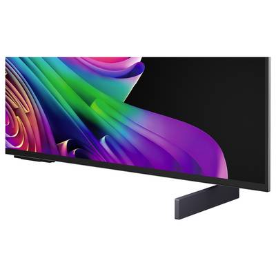 A widescreen TV or monitor displaying a colorful abstract ribbon pattern on a black screen, shown on a stand against a white background.