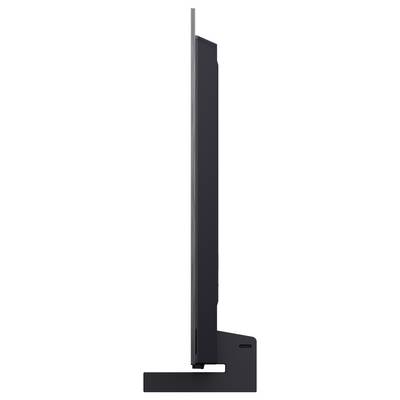 Side view of a slim black flat-screen display on a rectangular stand, showing the monitor’s profile and base.