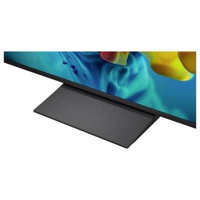 Close-up of a flat-screen TV with a slim black stand on a white background, showing a colorful abstract display.