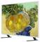 Flat-screen TV displaying a still life painting of yellow fruit in a woven basket, with green foliage and a blue cloth background.
