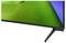 Close-up of a flat-screen TV or monitor showing a green and blue abstract display on a stand.