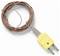 Coiled thermocouple wire with exposed ends and yellow two-prong electrical plug adapter on a white background.