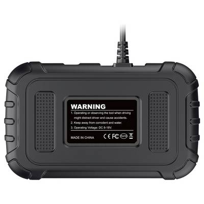 Back view of a rugged black electronic device with a warning label showing operating instructions and voltage, connected by a cable at the top.