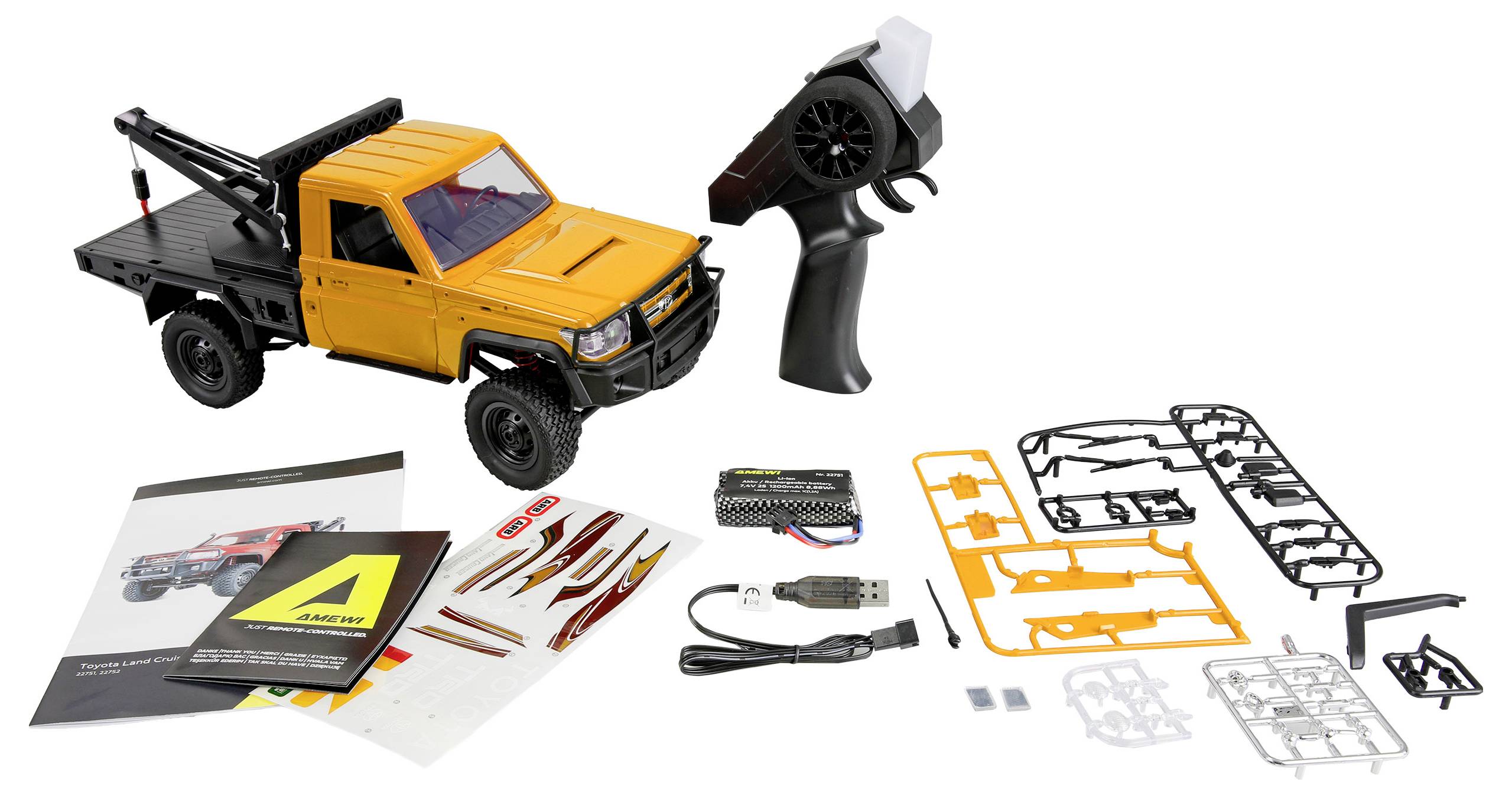 Orange remote-controlled pickup truck kit with transmitter, battery, USB charger, instruction manual, decals, and assembly parts laid out on a white background.