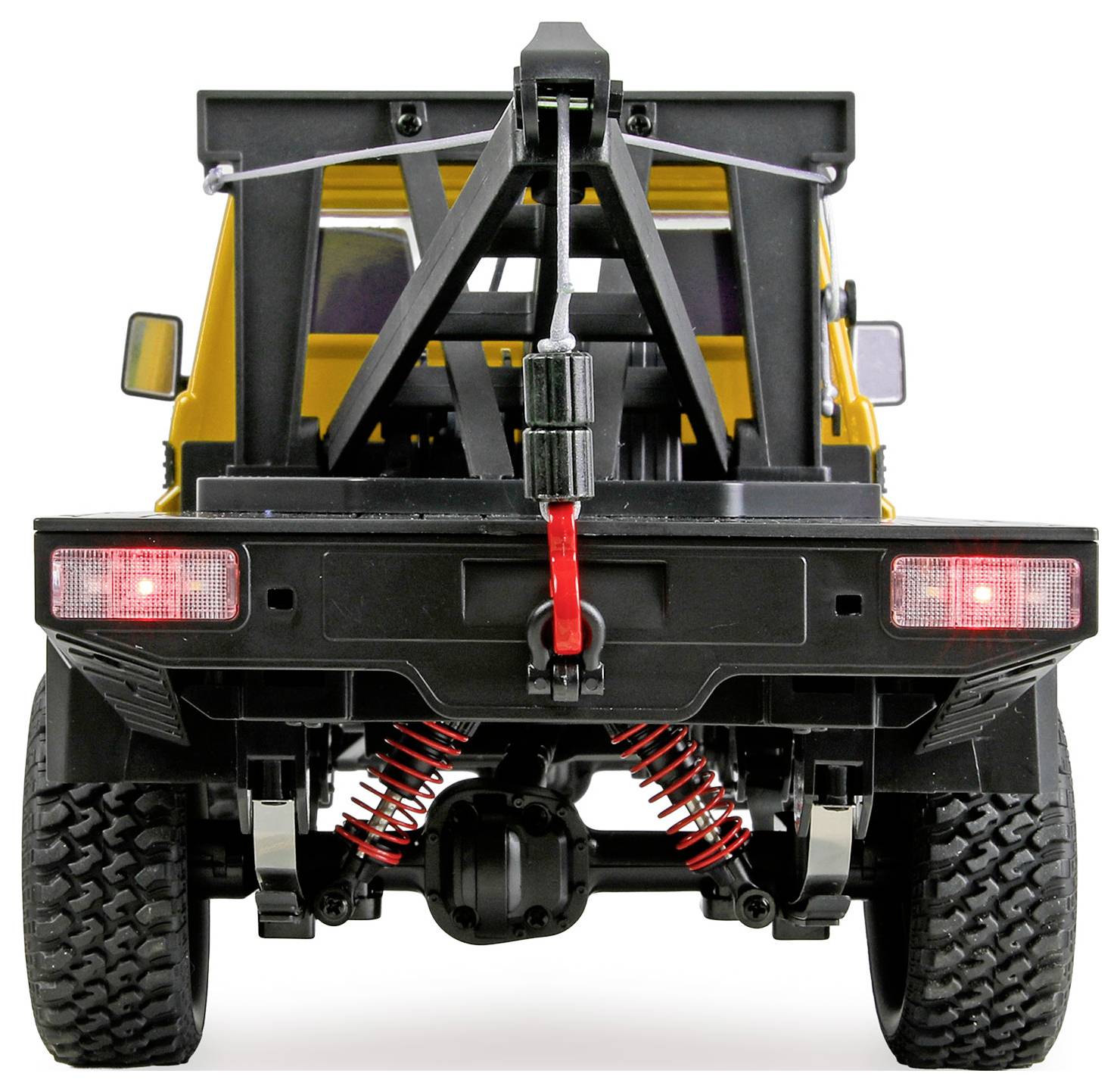 Rear view of a yellow off-road tow truck or recovery vehicle with black frame, spare tire mount, red tow hook, and large tires on a white background.