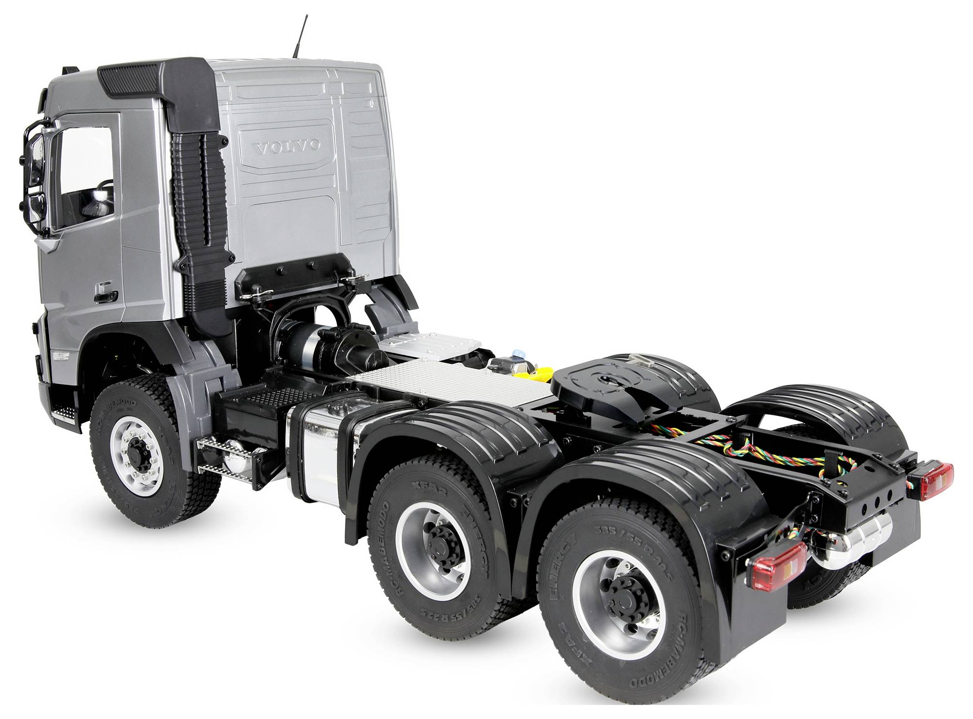 Rear three-quarter view of a silver Volvo semi-truck cab chassis with no trailer, showing the exposed frame, six wheels, and rear axle components on a white background.