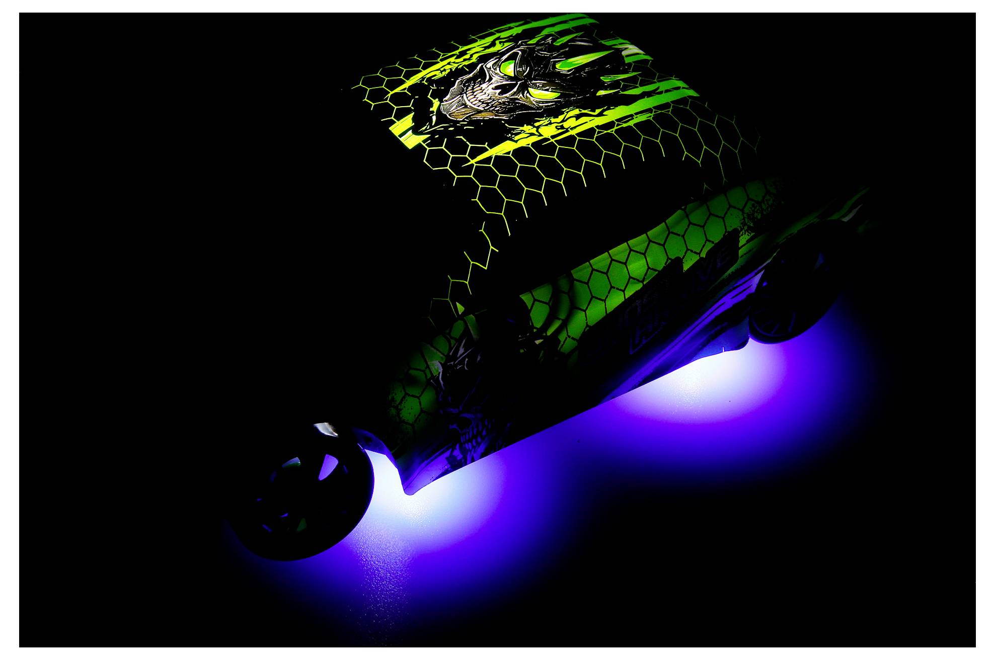 A dark electric skateboard glowing green and blue, shown at an angle against a black background.<br>