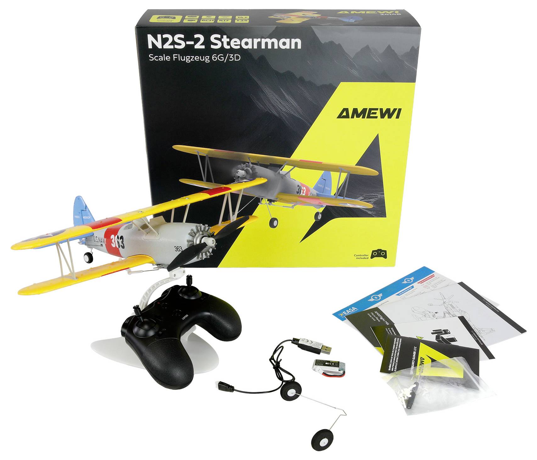 AMEWI N2S-2 Stearman scale RC airplane kit with box, controller, battery, charger, manuals, and small parts laid out on a white background.
