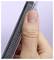 Close-up of a hand holding a black comb against a light purple background.