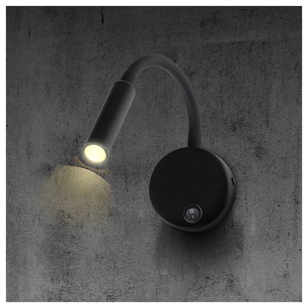 Black wall-mounted adjustable reading light with a round base, lit and shining a warm beam onto a concrete wall.<br>
