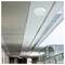 Modern corridor ceiling with recessed lights and glass railing in a bright office or public building interior.