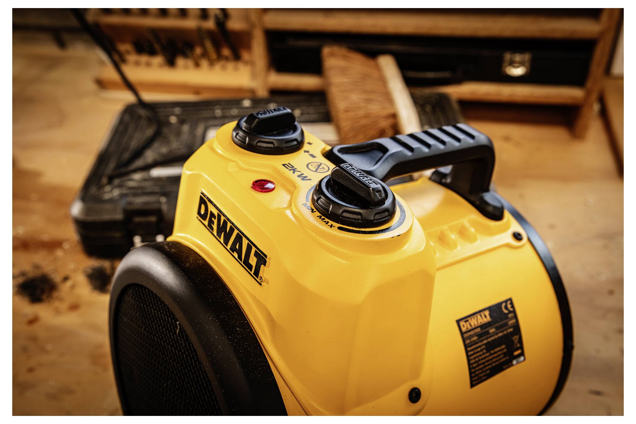 Yellow DEWALT portable electric space heater with black handle and control dials, shown on a workshop floor.