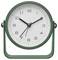 Green analog desk clock showing about 10:10, with a second hand near 7.