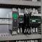 Control cabinet with multiple Schneider Electric control devices and wired relays/contactors on DIN rail.