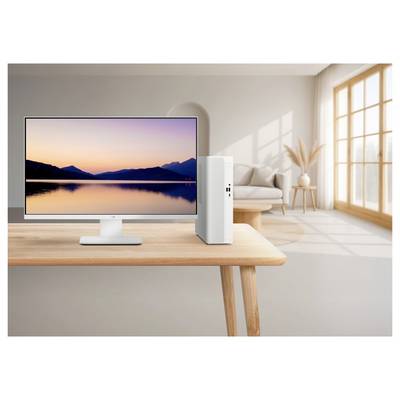 Desktop computer monitor on a wooden table displaying a sunset lake landscape in a bright modern living room.