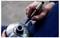 Close-up of a hand marking a metal part with a blue 'Edding 750' permanent marker.