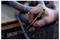 Hand using a black marker to label a gray hose or cable 'Ecoline' and 'coating 51' near industrial equipment.