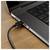 Close-up of a laptop’s side with a USB-C cable plugged into the port on a wooden desk.<br>