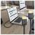 Two USB-C cables plugged into a laptop and a desktop monitor on a desk, with the screens showing analytics dashboards.