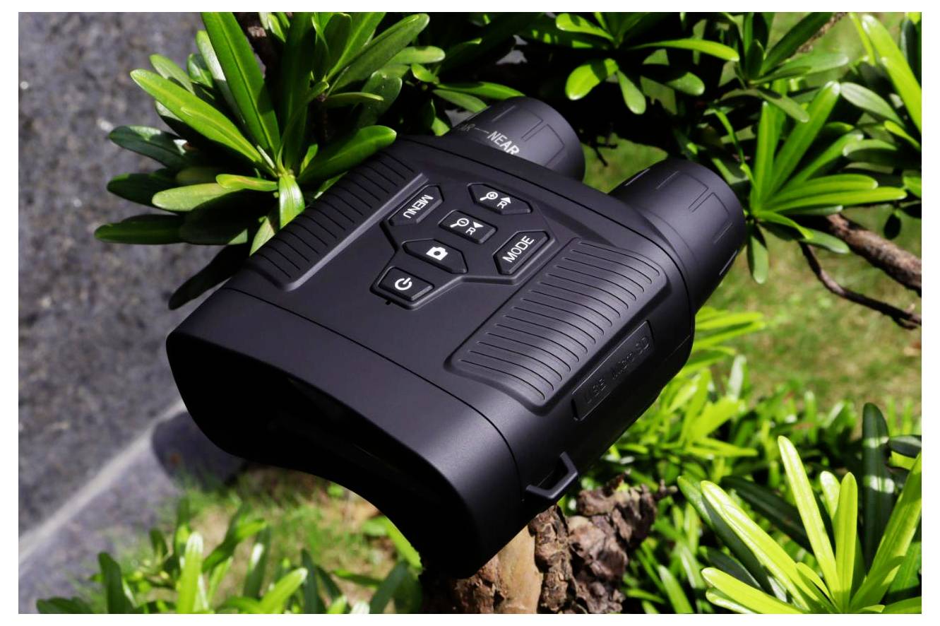 Black binoculars mounted on a tree branch among green leaves, with control buttons visible on top.