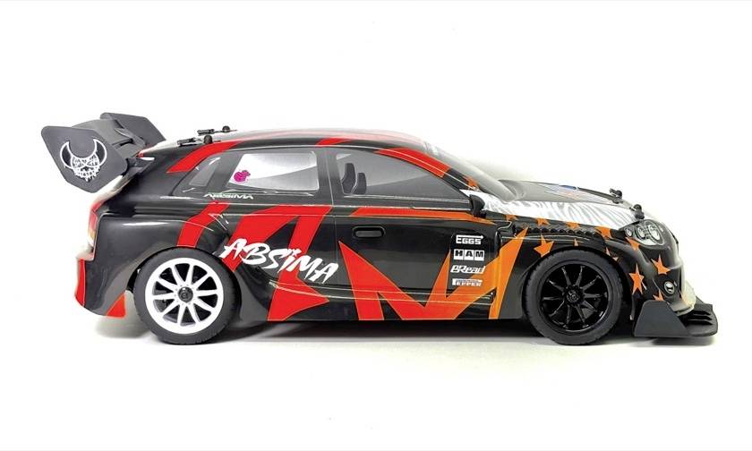 Side view of a black and red racing model car with a large rear wing and sponsor decals on a white background.