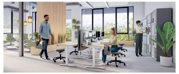 Modern open-plan office with one man carrying a laptop bag, one woman working at a desk, and another person accessing a server cabinet.
