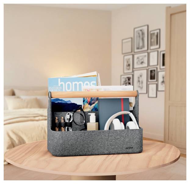 Gray felt caddy on a round wooden table holds books, headphones, toiletries, and other personal items in a bedroom.<br>