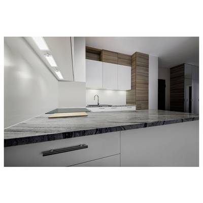 Modern kitchen interior with a large gray marble island, white cabinets, wood accents, and recessed ceiling lights.<br>