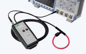 Handheld test probe connected by cable to an electronic test instrument, with a red loop attachment in the foreground.