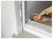 Hand using an orange oscillating tool to cut or scrape a door frame or window trim during repair work.
