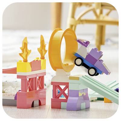 Colorful toy blocks form a fire-jump ramp, with a small purple car leaping through an orange ring.