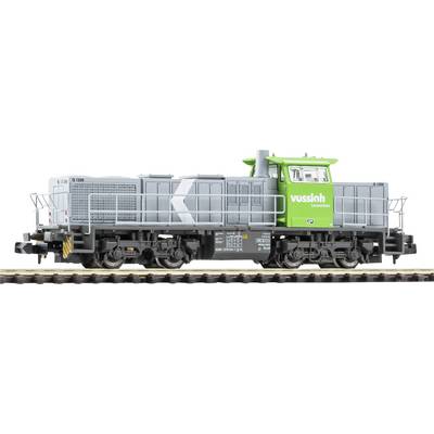 Green Vossloh rail maintenance locomotive with gray body and black undercarriage, shown in side view on tracks.